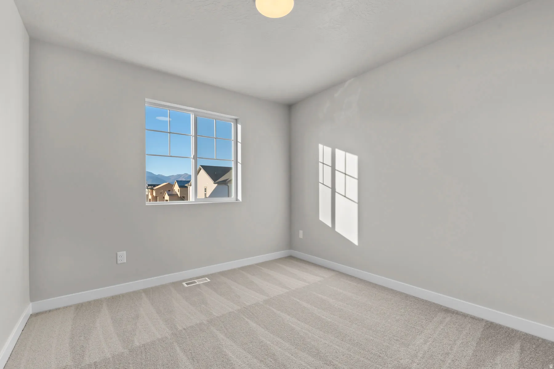 Neutral-toned interior room featuring light gray walls and coordinating patterned carpeting