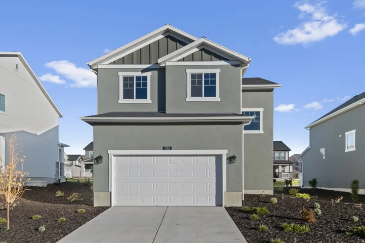 Contemporary two-story residence with a stucco and board-and-batten facade, featuring white trim and a prominent two-car garage