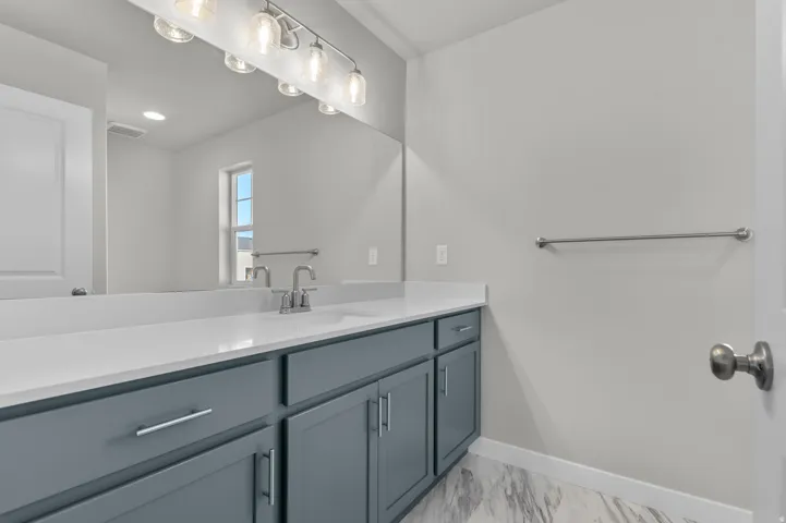 Bathroom featuring a wide vanity with a single sink, light gray cabinetry, and a white countertop