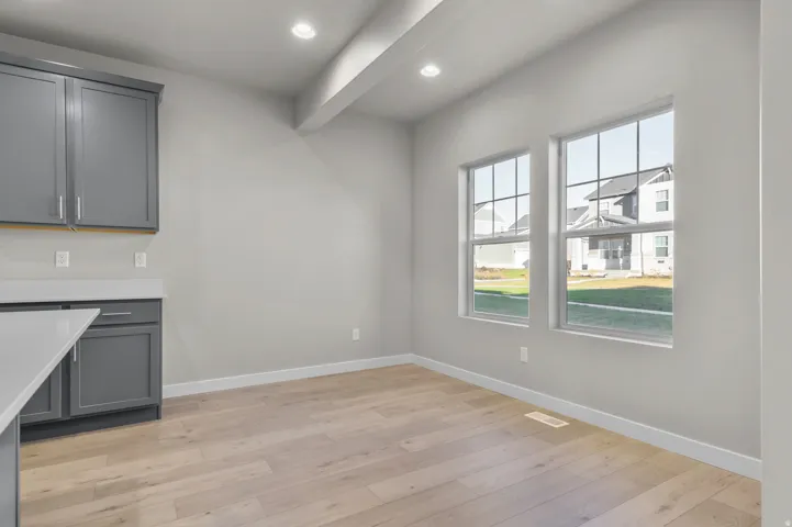 Bright interior space featuring light wood-finish flooring, recessed lighting, and dual gridded windows