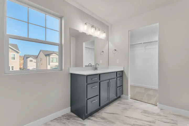 Dual vanity with gray cabinetry, white countertop, and chrome fixtures