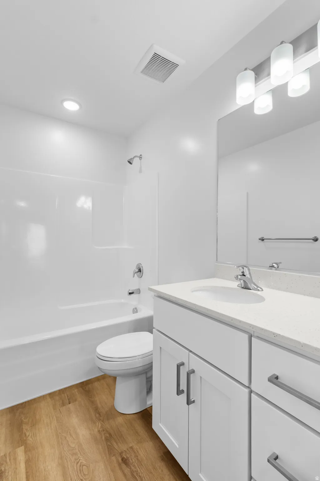 Bathroom featuring a white vanity with a light-colored countertop, chrome faucet, and integrated sink