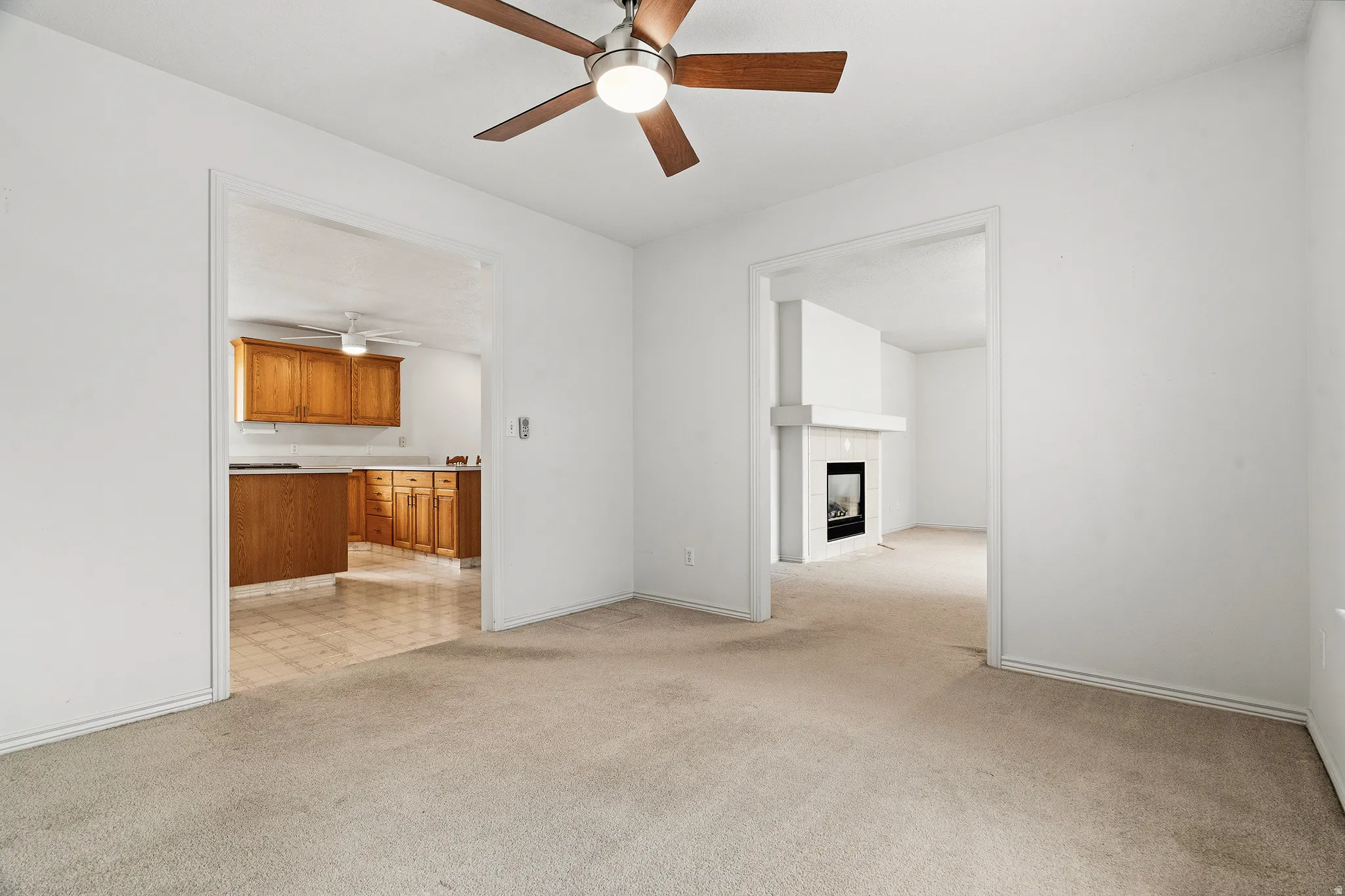 Carpeted interior space with a ceiling fan light fixture