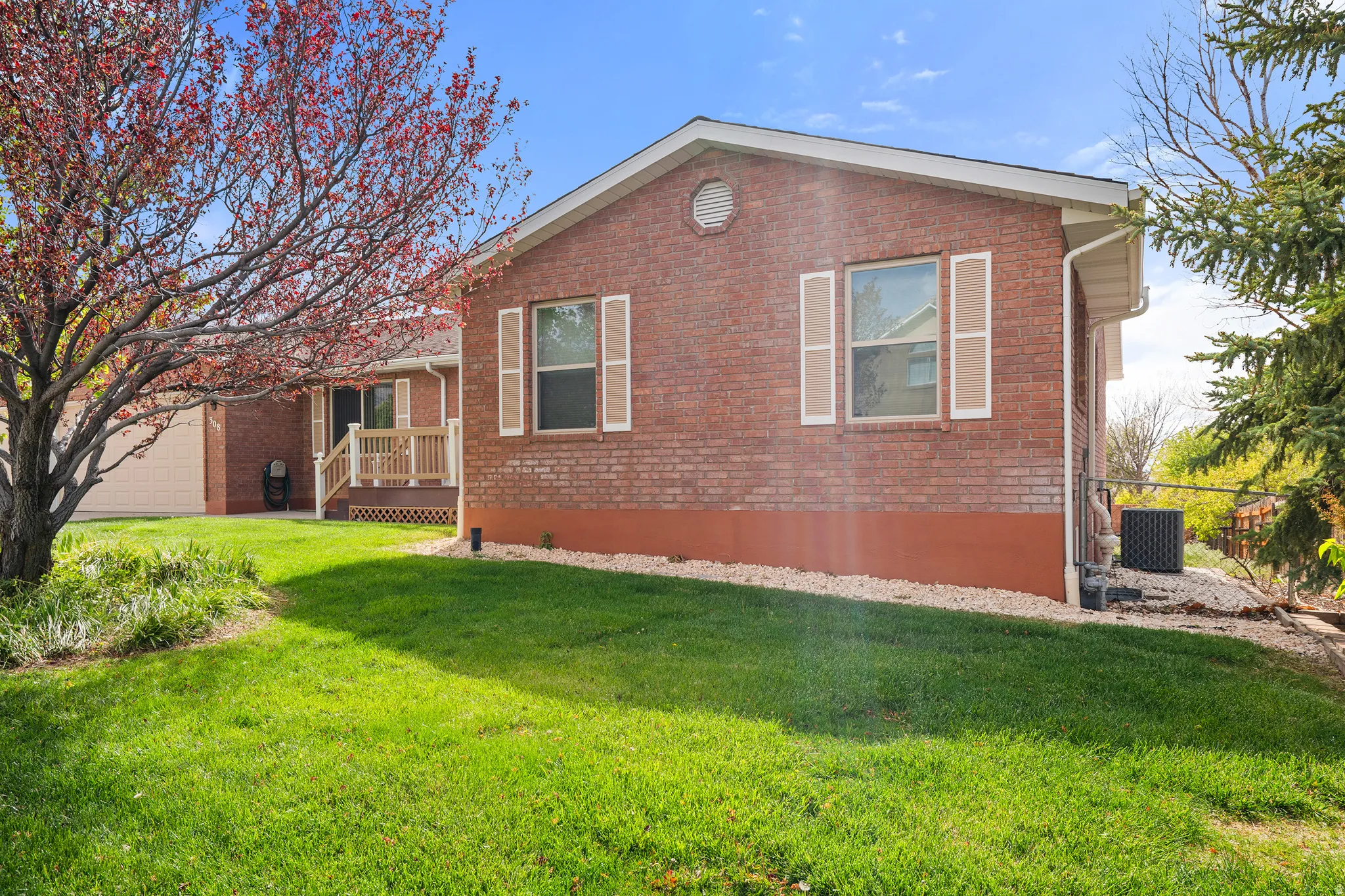 Brick exterior featuring a portico entry with a wooden railing and steps