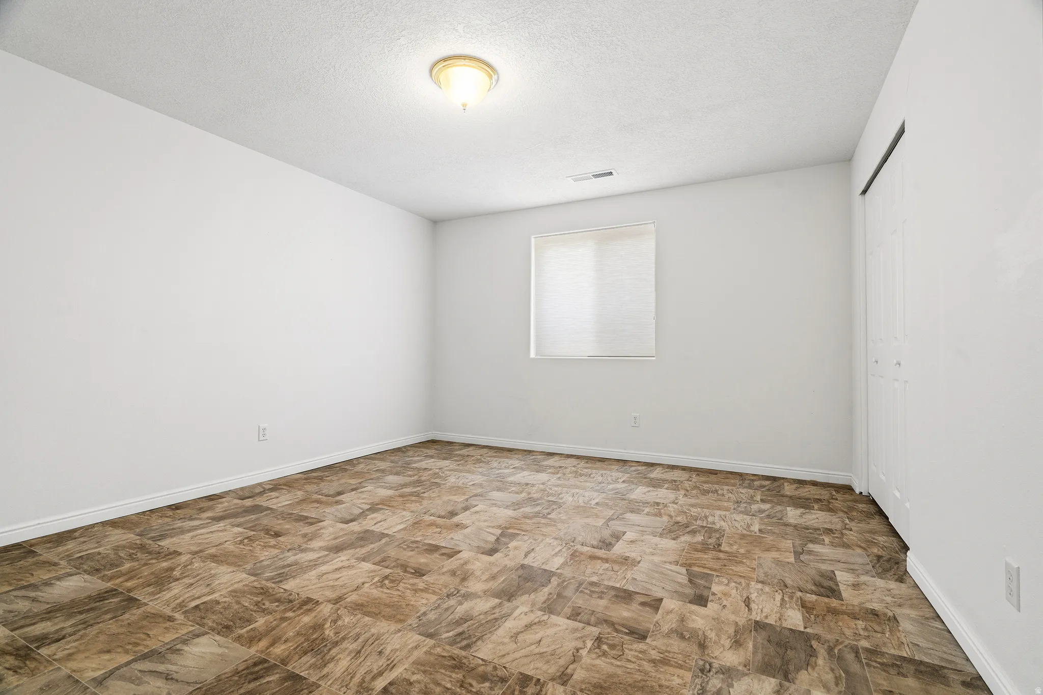 Room featuring patterned resilient flooring and white baseboards