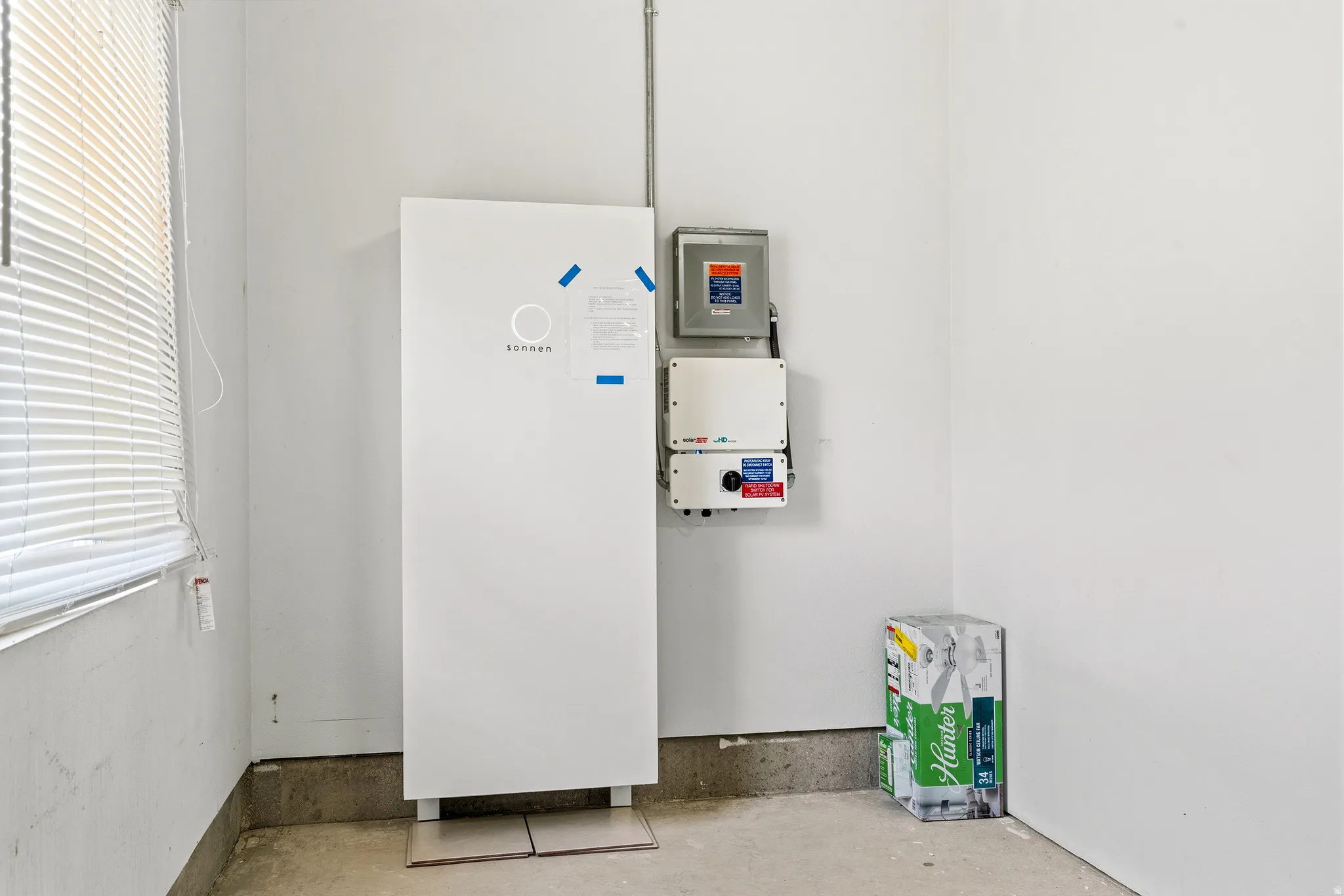 Integrated battery storage system with wall-mounted electrical components and concrete flooring