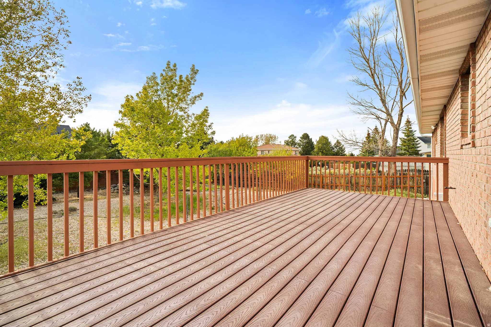 Spacious outdoor deck featuring wood-finish flooring and a wood railing system