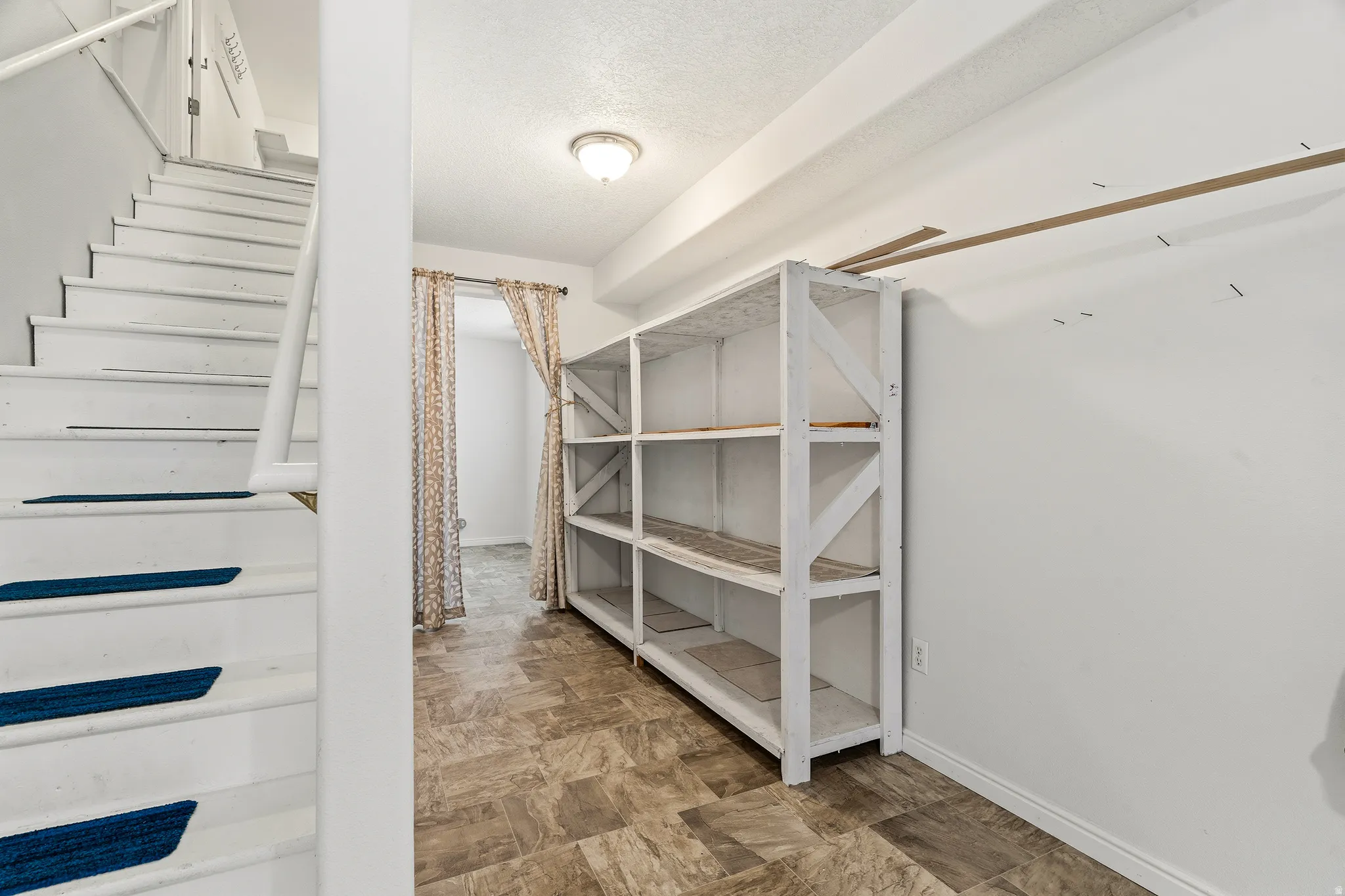 Finished basement space featuring wood-finish flooring and a built-in shelving unit