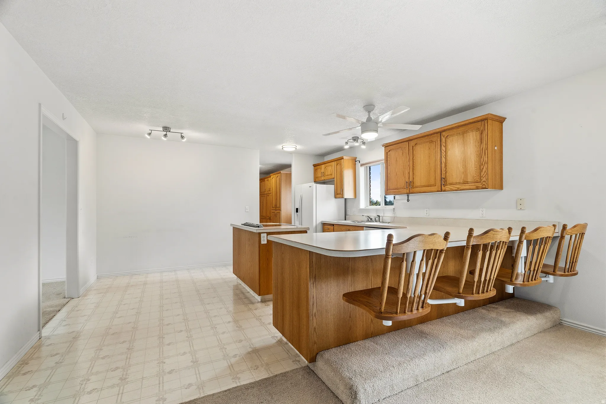 Kitchen featuring wood cabinetry, light countertops, and a ceiling fan