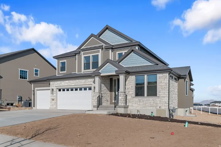 Contemporary two-story residence featuring a stone and siding exterior, multi-pane windows, and a covered front entry