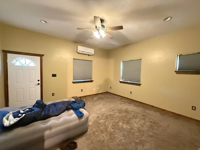 Spacious room featuring neutral carpeting, a ceiling fan with integrated lighting, and recessed ceiling lights