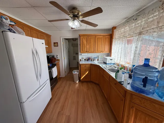 Kitchen featuring wood-finish flooring, wood cabinetry, and a ceiling fan