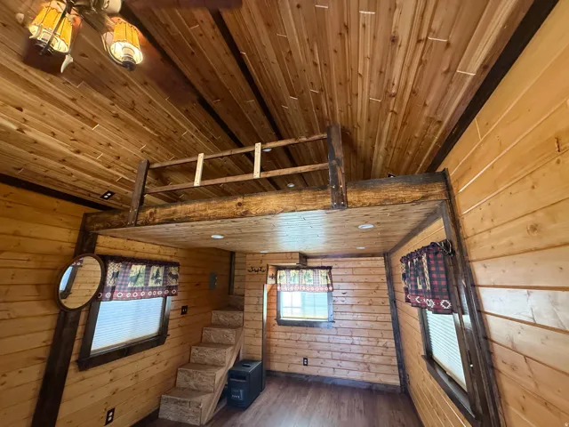Interior loft space featuring natural wood-finish walls and ceilings, a wood-finish staircase, and wood-finish flooring