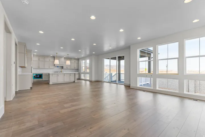 Open-concept living space featuring wood-finish flooring, recessed lighting, and expansive windows