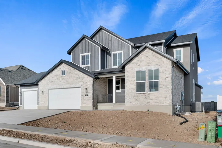 Contemporary exterior featuring a stone and siding facade, multi-pane windows, and a multi-car garage with two distinct doors