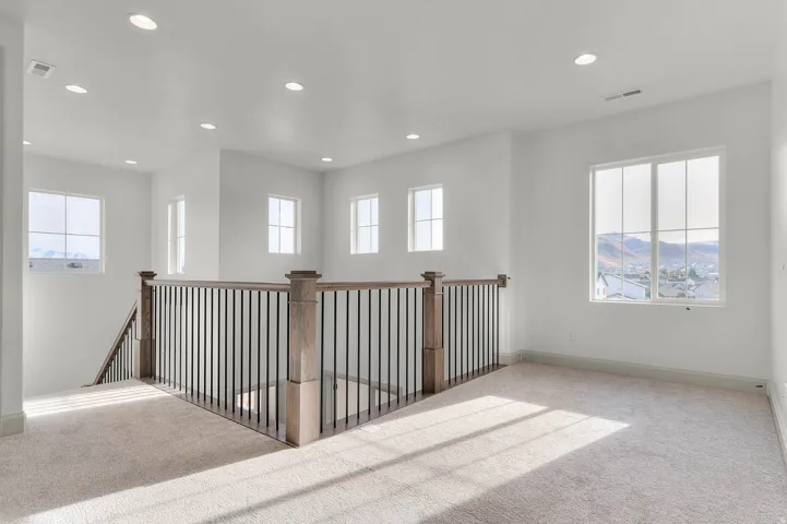 Spacious upper level with neutral carpet flooring and white walls