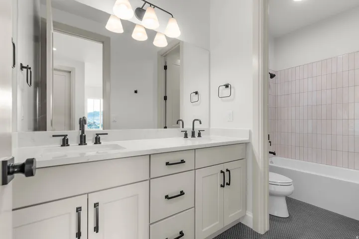 Dual vanity with undermount sinks, white countertops, and matte black fixtures