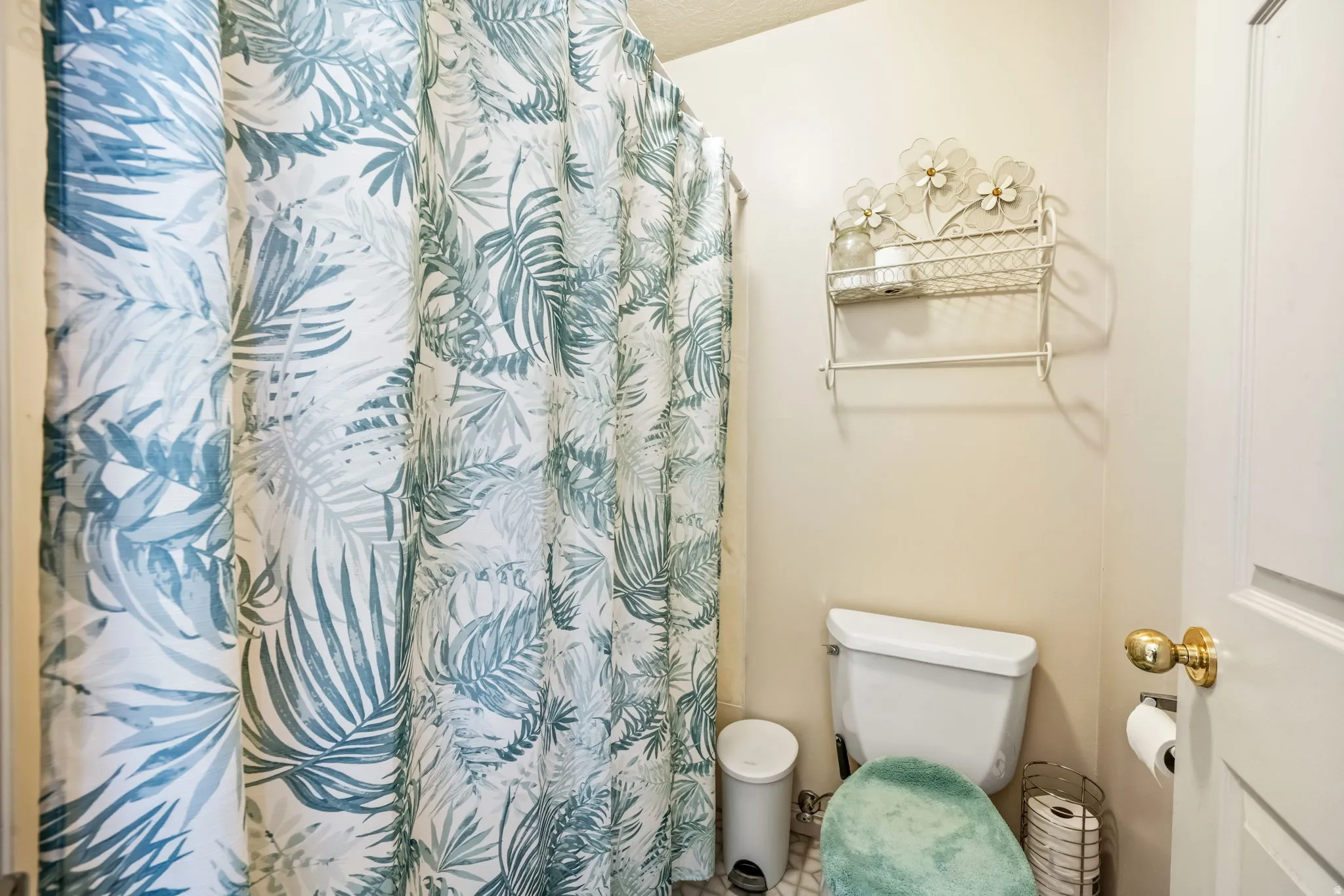 Full bathroom featuring a white toilet, light-toned walls, and a white interior door with a brass-finish knob