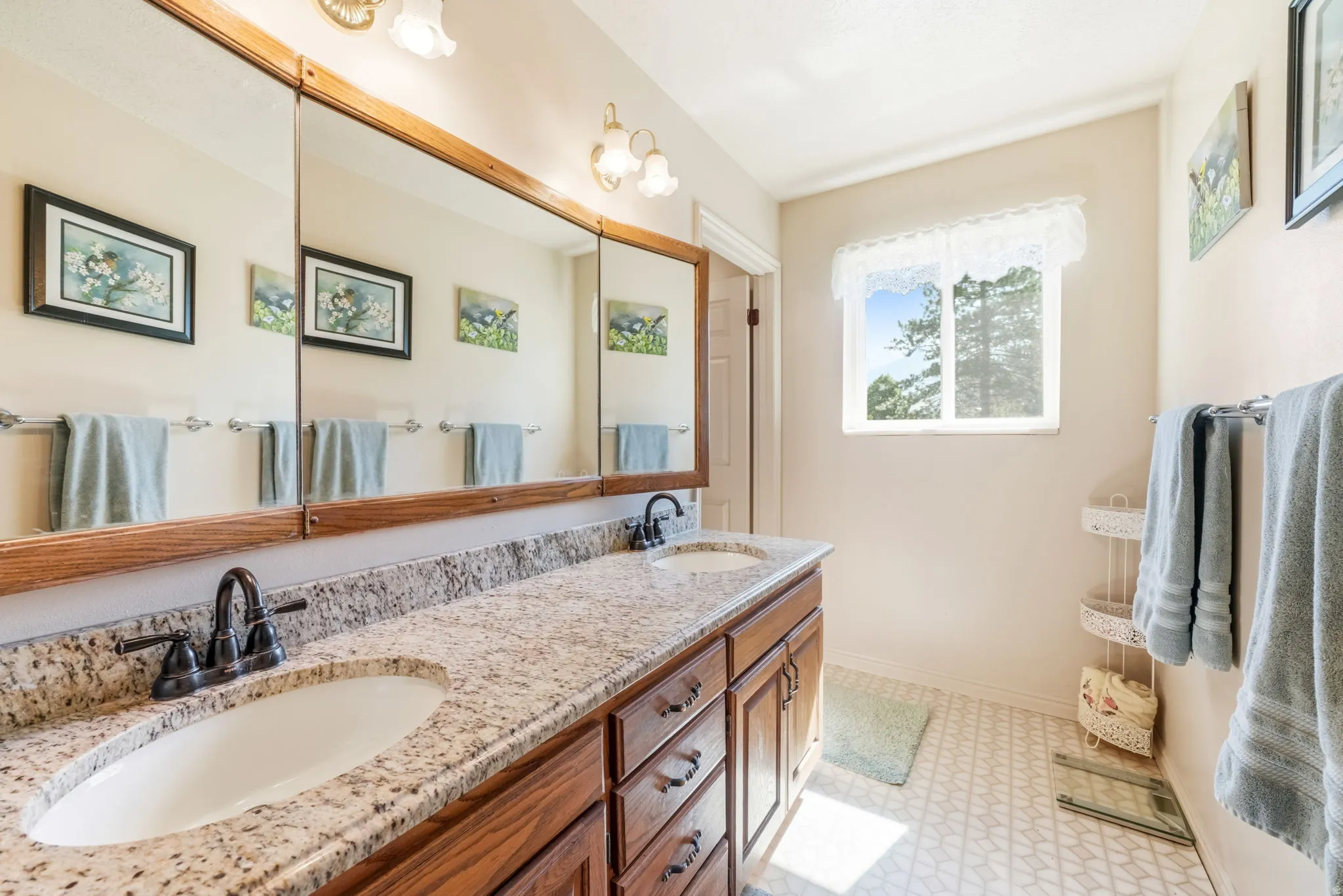 Dual vanity with stone-finish countertop, undermount sinks, and dark bronze-finish fixtures