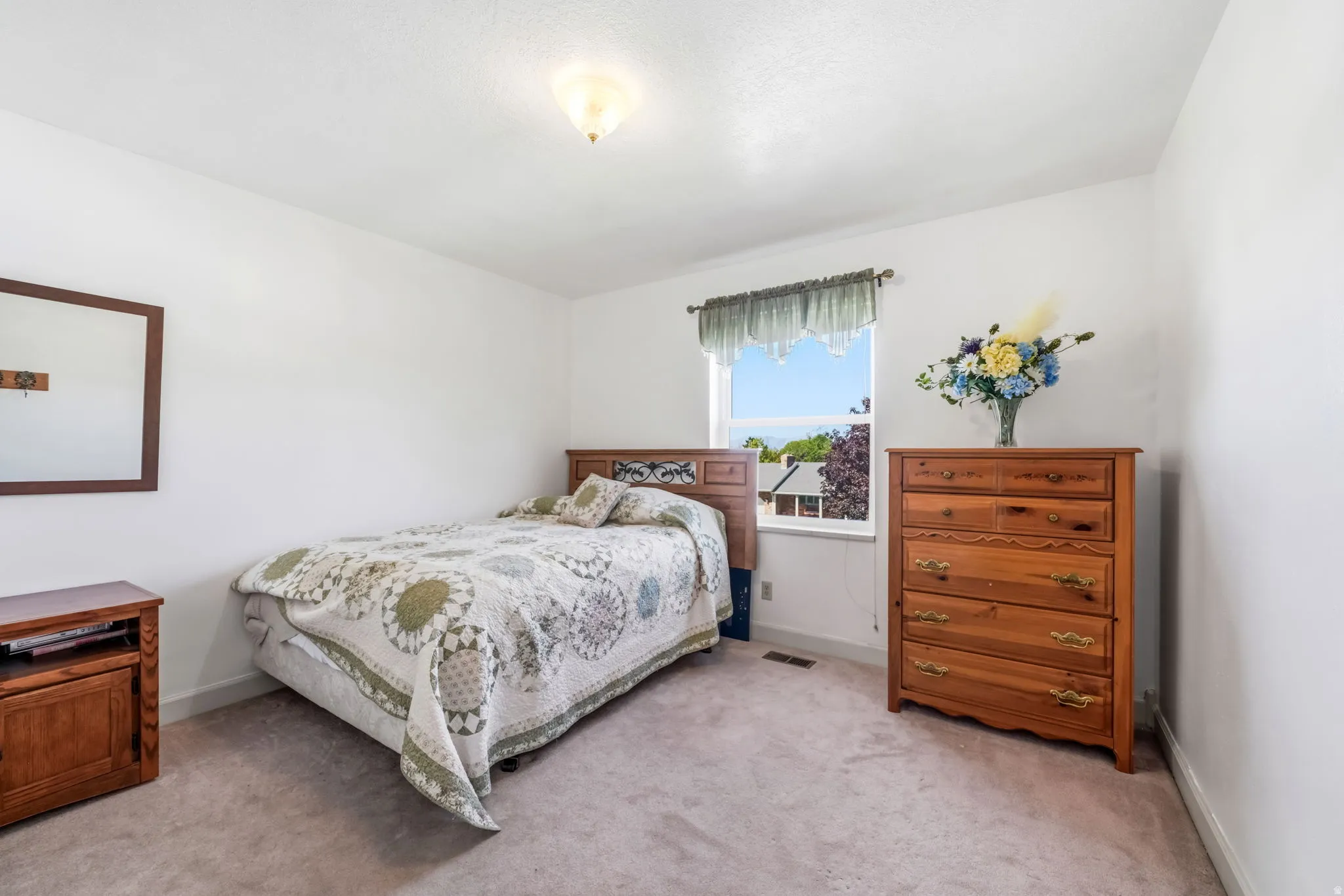 Carpeted room featuring a single window with white trim, a flush-mount ceiling light, and white baseboards