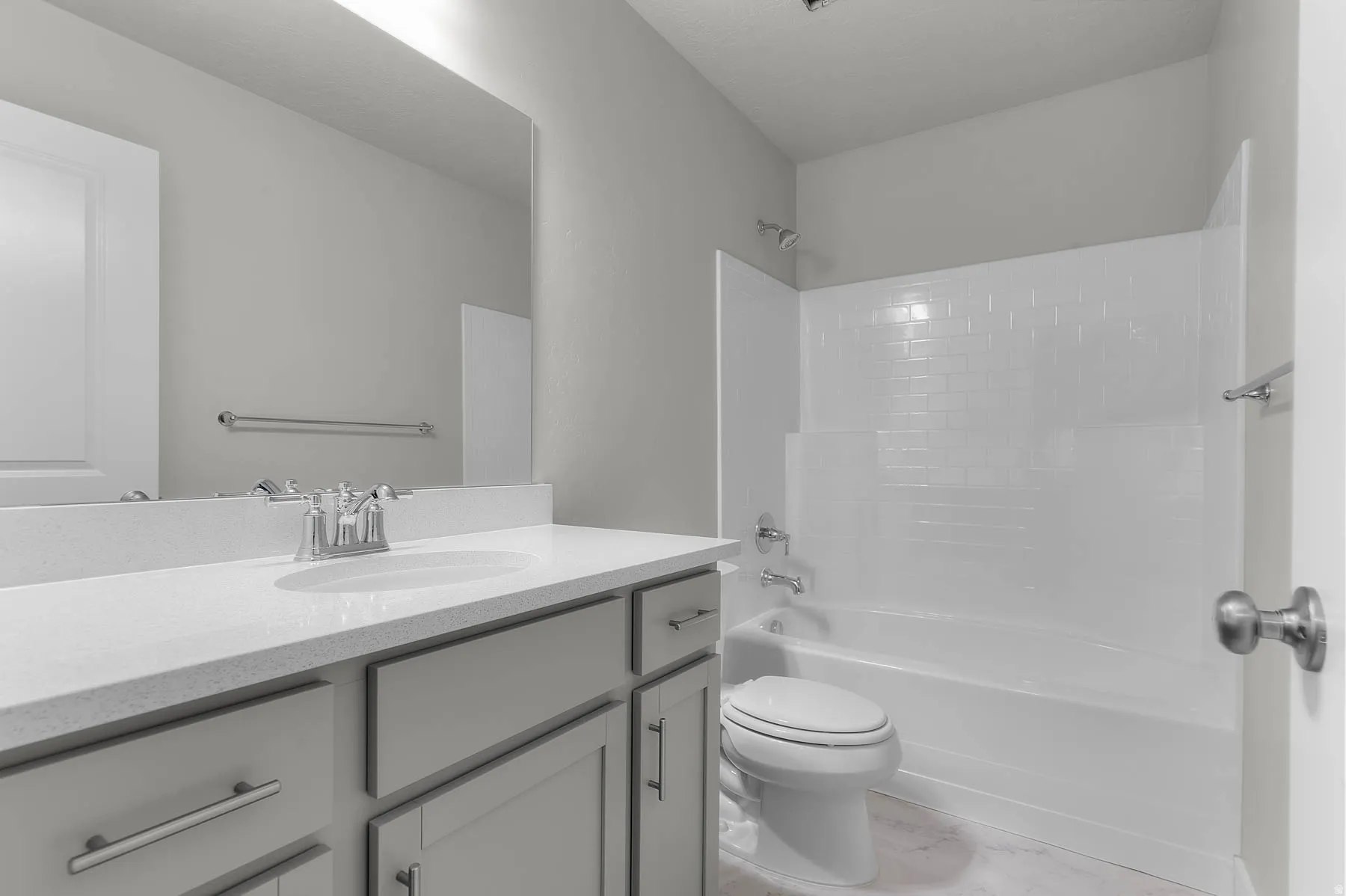 Bathroom featuring a vanity with an integrated sink, light-colored countertop, and gray shaker-style cabinetry