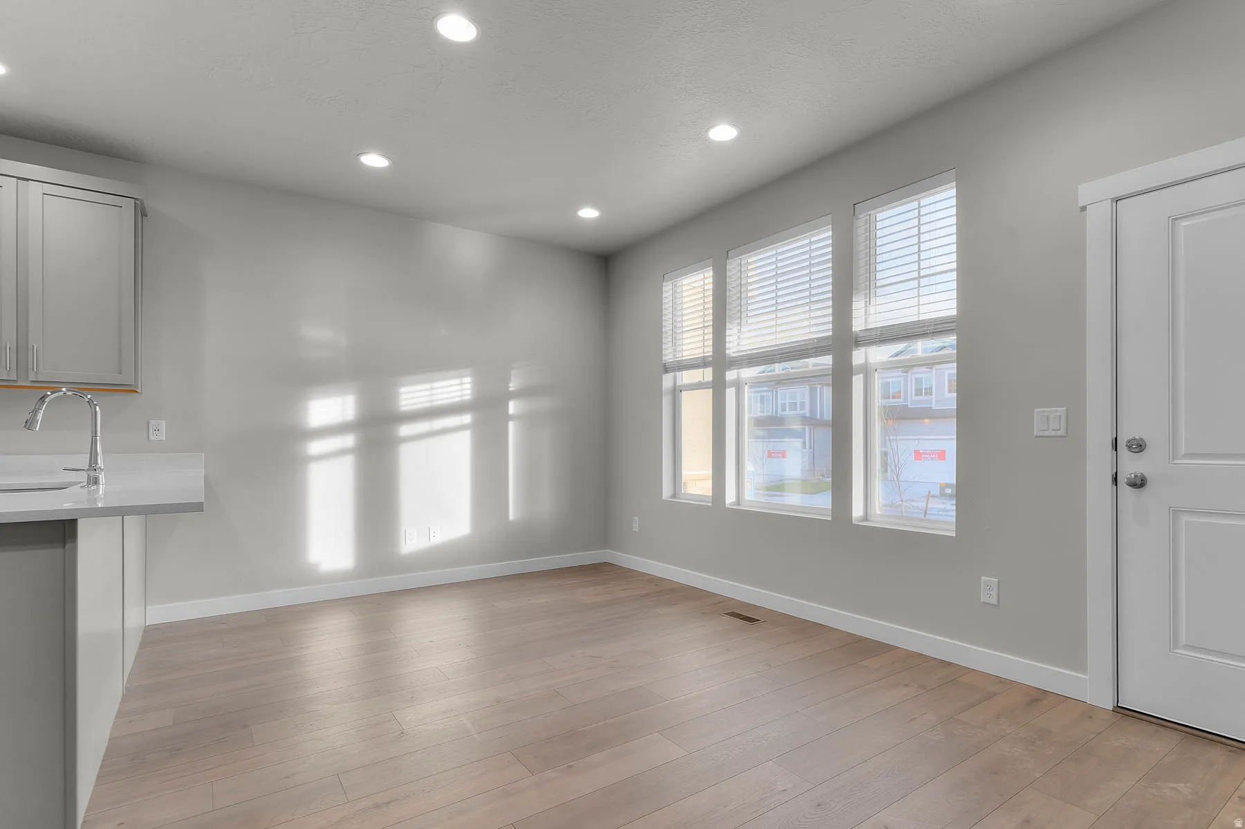 Open concept living space featuring light wood-finish flooring and recessed lighting