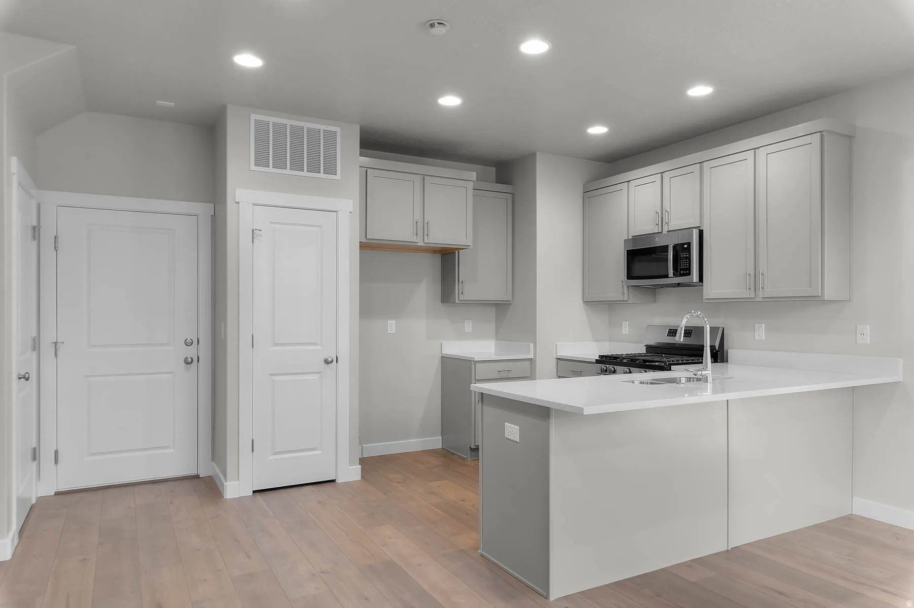 Modern kitchen featuring light wood-finish flooring and recessed lighting