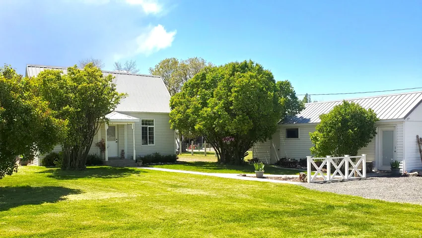 Expansive green lawn with mature trees and a gravel pathway