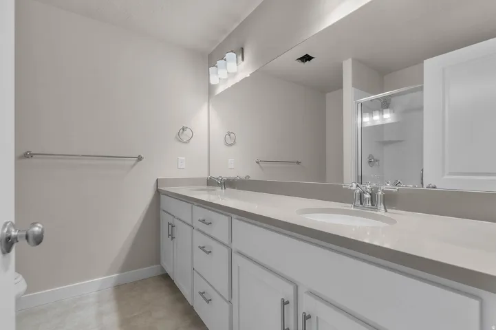 Dual vanity with light gray countertops and white cabinetry
