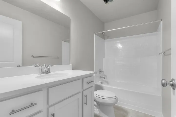 Full bathroom featuring a white vanity with an integrated sink, chrome faucet, and a large wall-mounted mirror