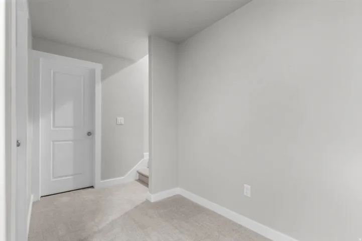 Light gray wall tones with white trim, featuring plush carpet flooring