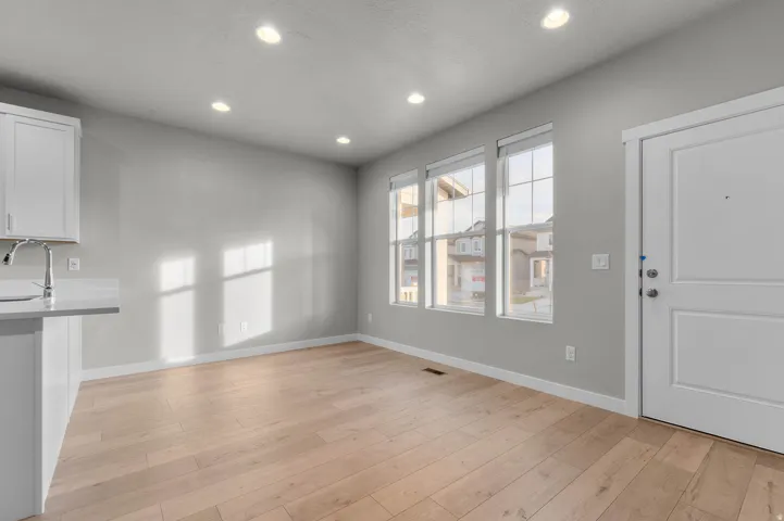 Open-concept living space with light wood-finish flooring, recessed lighting, and a neutral wall palette
