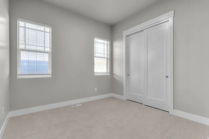 Interior room featuring neutral wall paint and light-toned carpet flooring