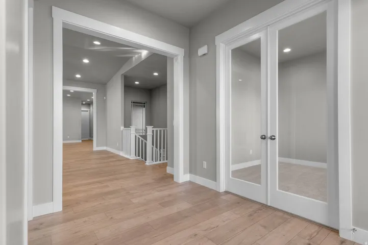 Light wood-finish flooring extending through an open hall