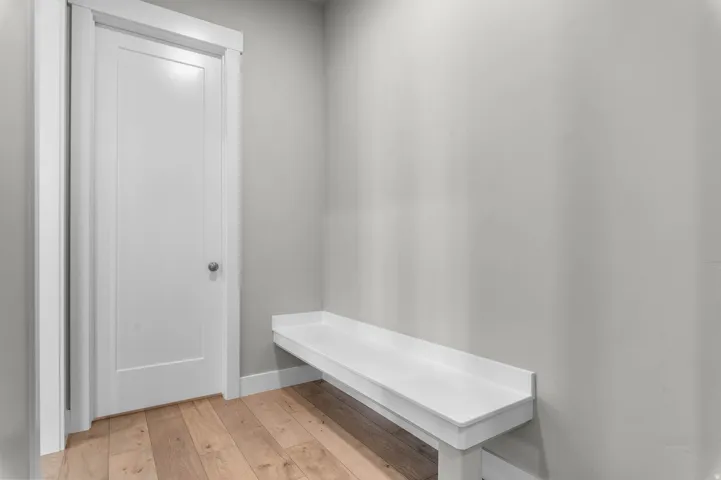Built-in white bench seating paired with light wood-finish flooring