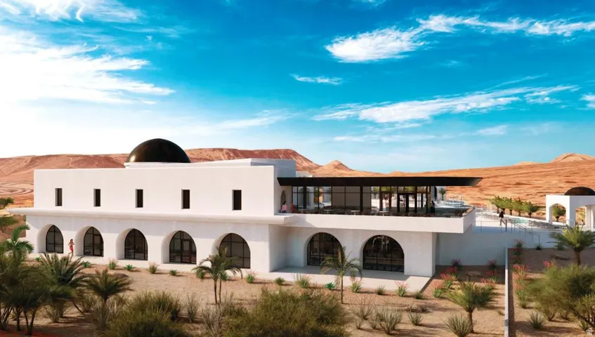 Modern white stucco exterior with arched window openings, a black dome accent, and an expansive upper-level terrace