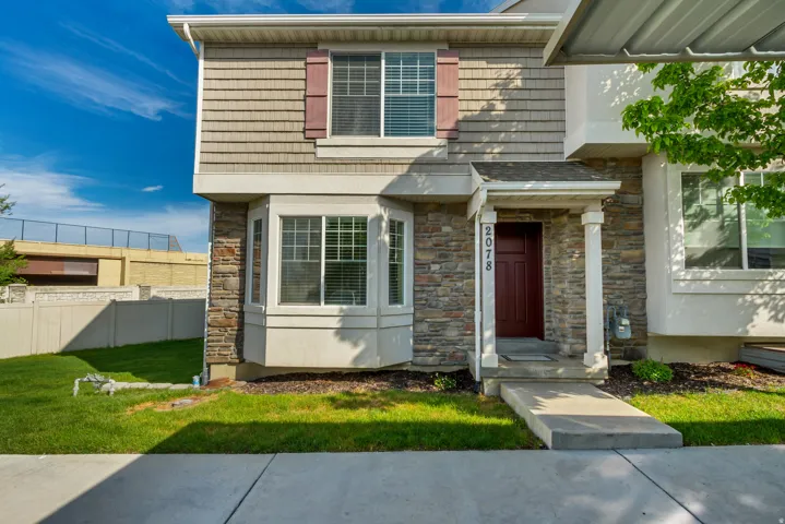 Exterior facade featuring stone veneer, horizontal siding, and decorative window shutters