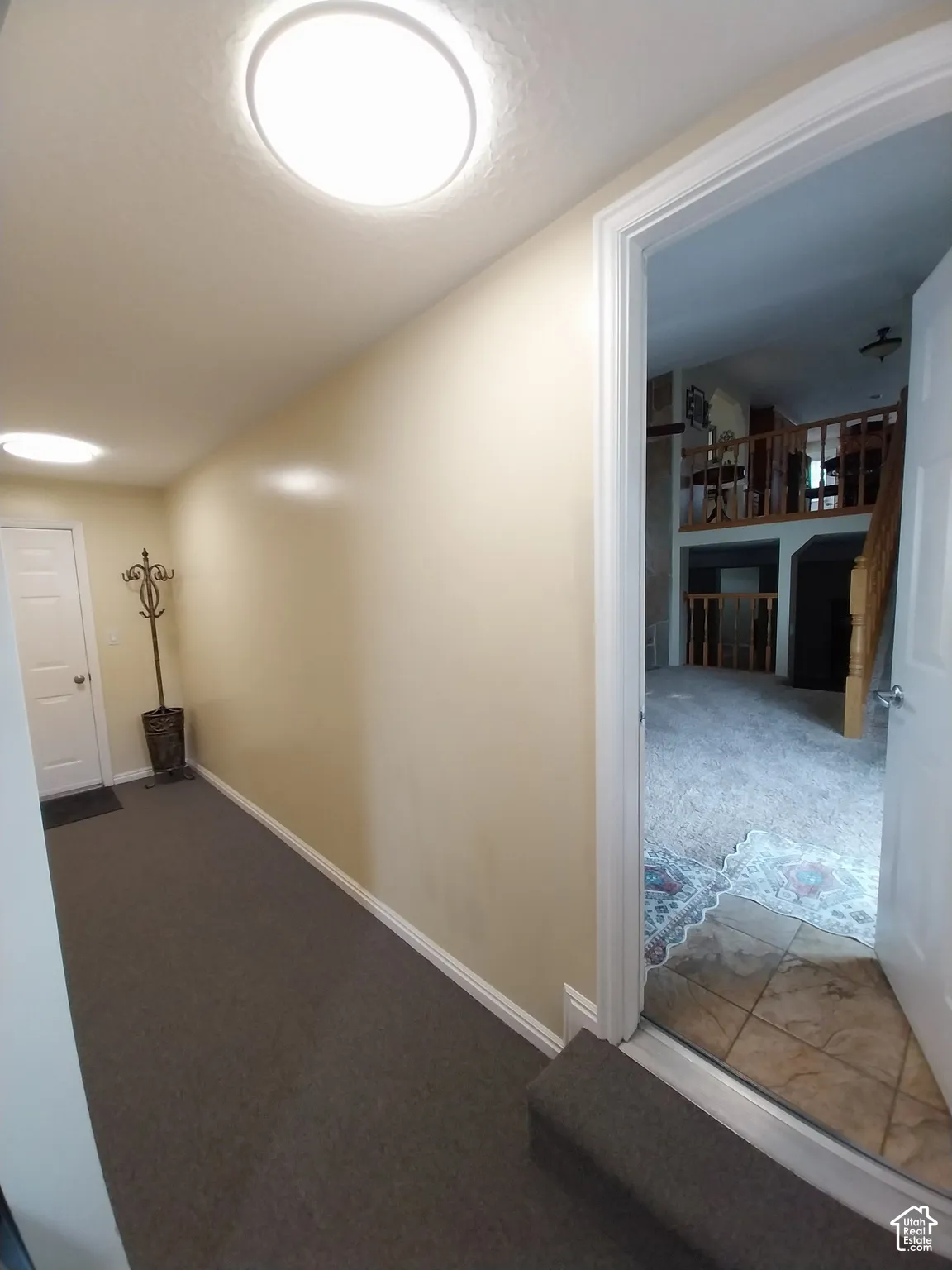 Garage hallway featuring gray colored carpet.