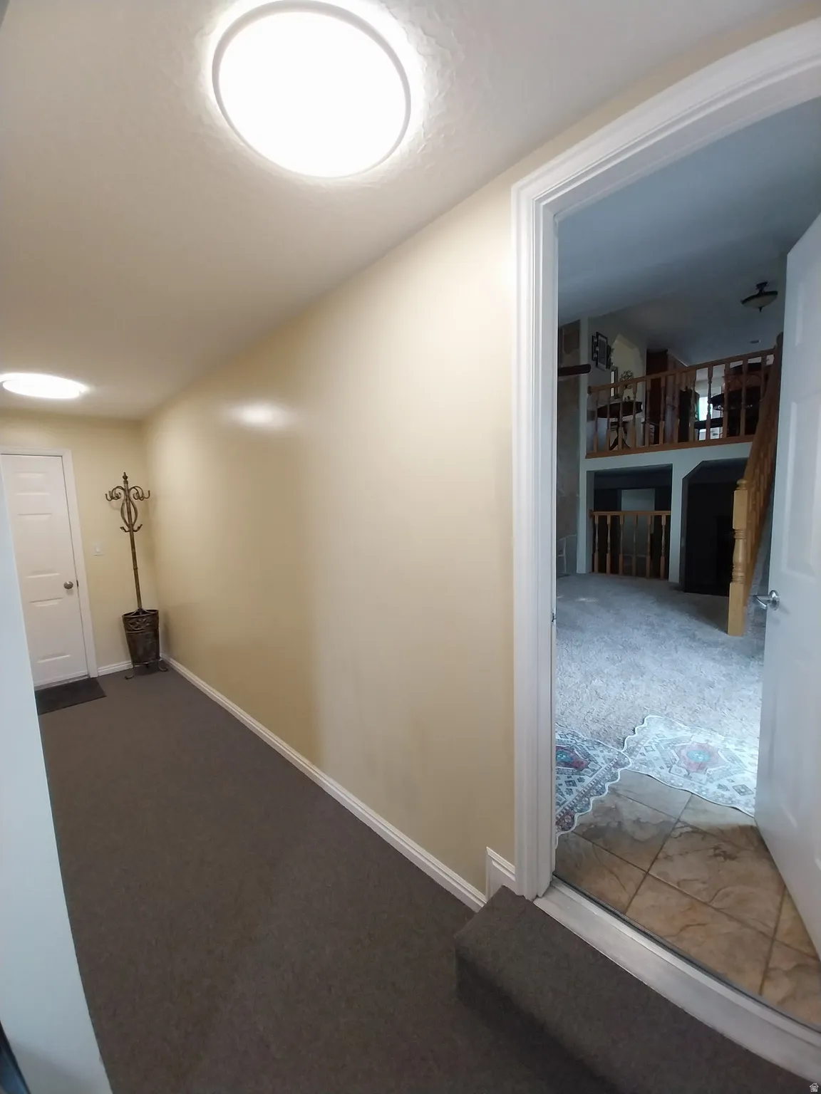 Garage hallway featuring gray colored carpet.