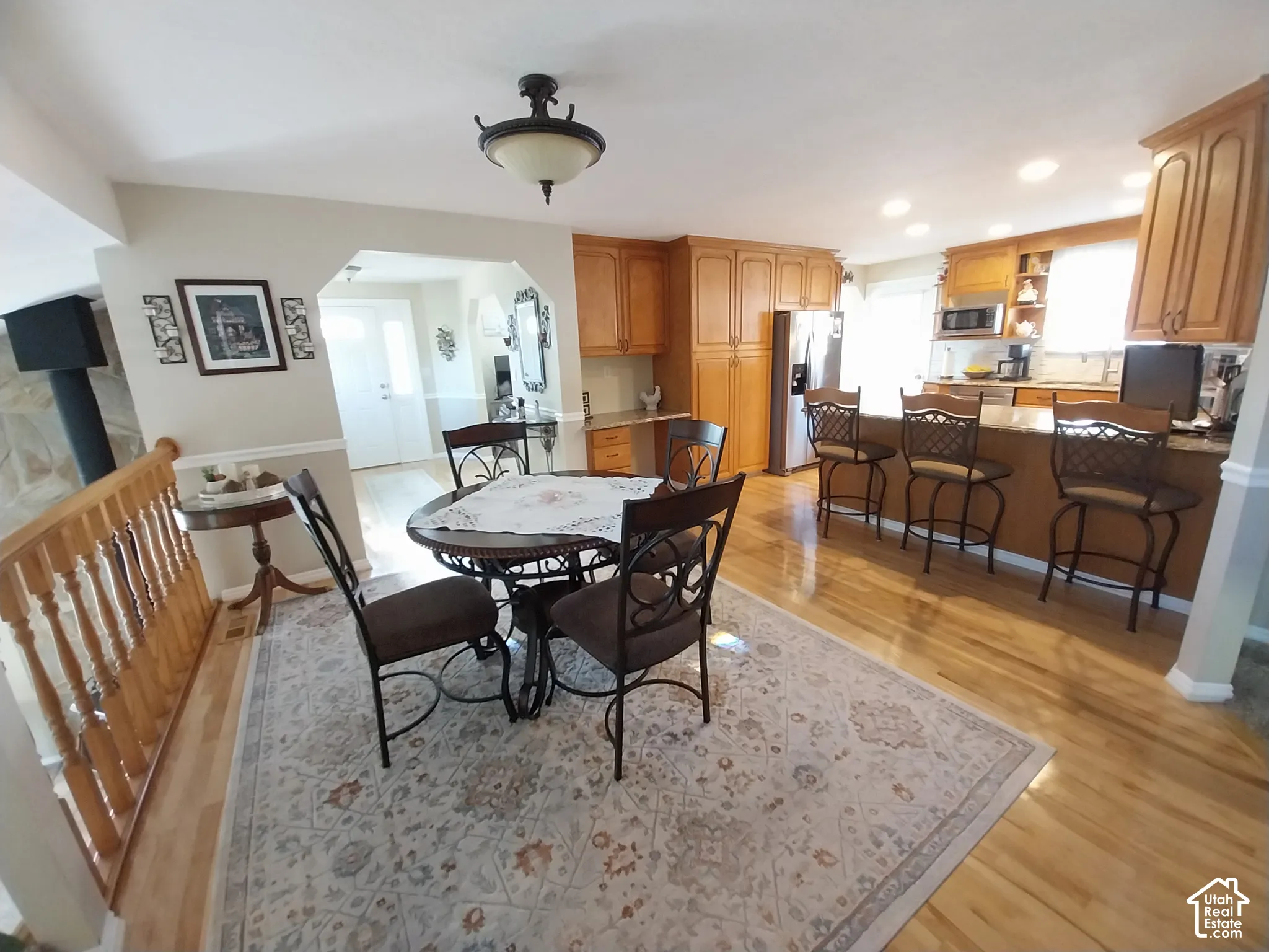 Dining room featuring light wood-style floors, arched walkways, and recessed lighting