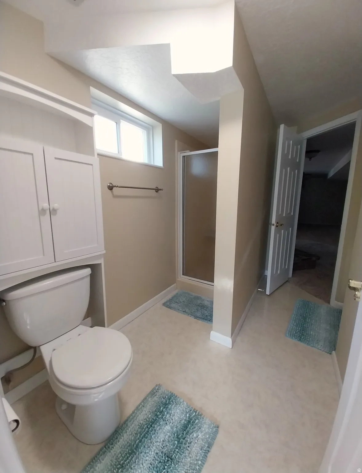 Bathroom featuring a shower stall and a toilet