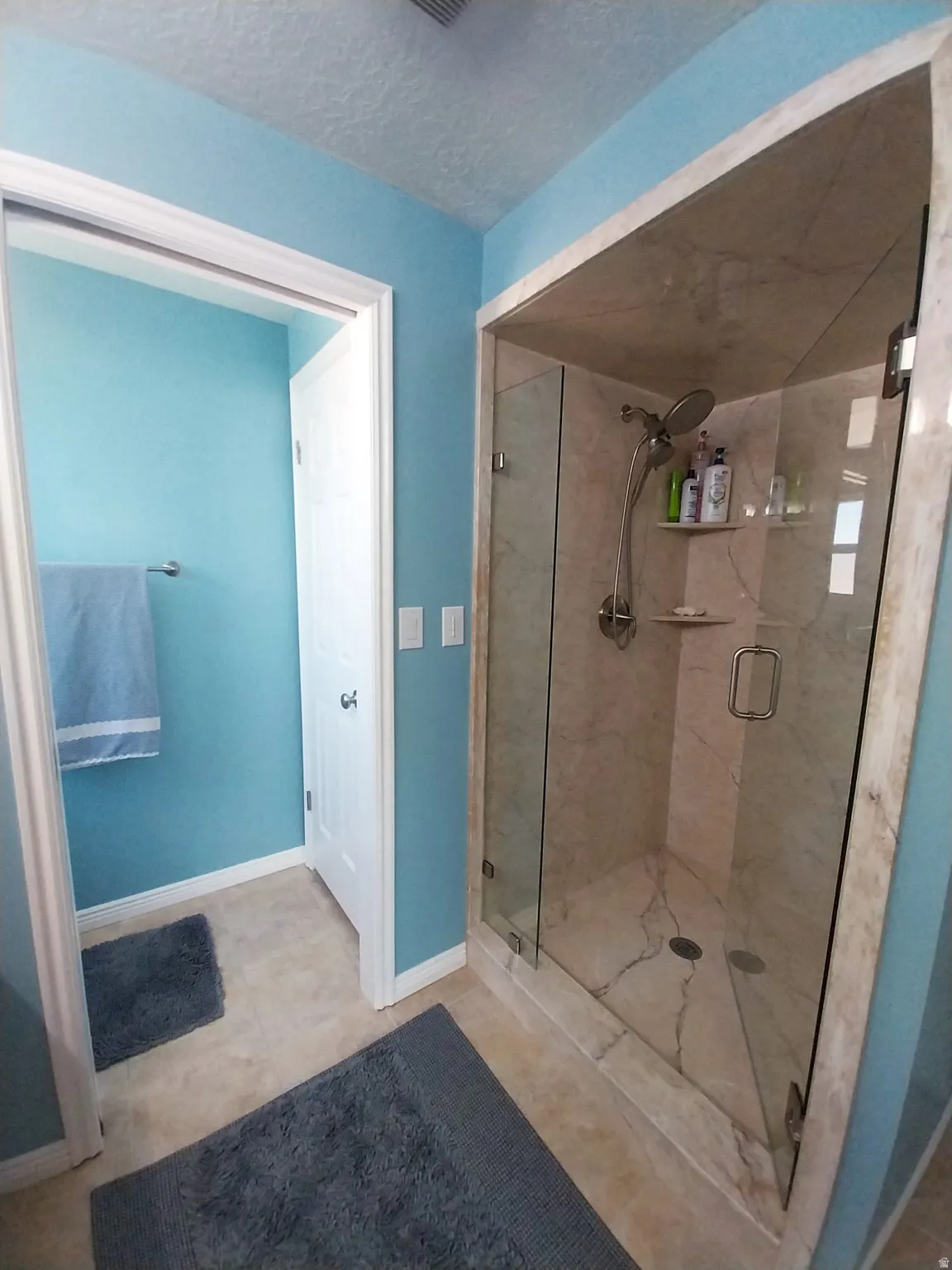 Bathroom featuring a stall shower, and light tile patterned floors