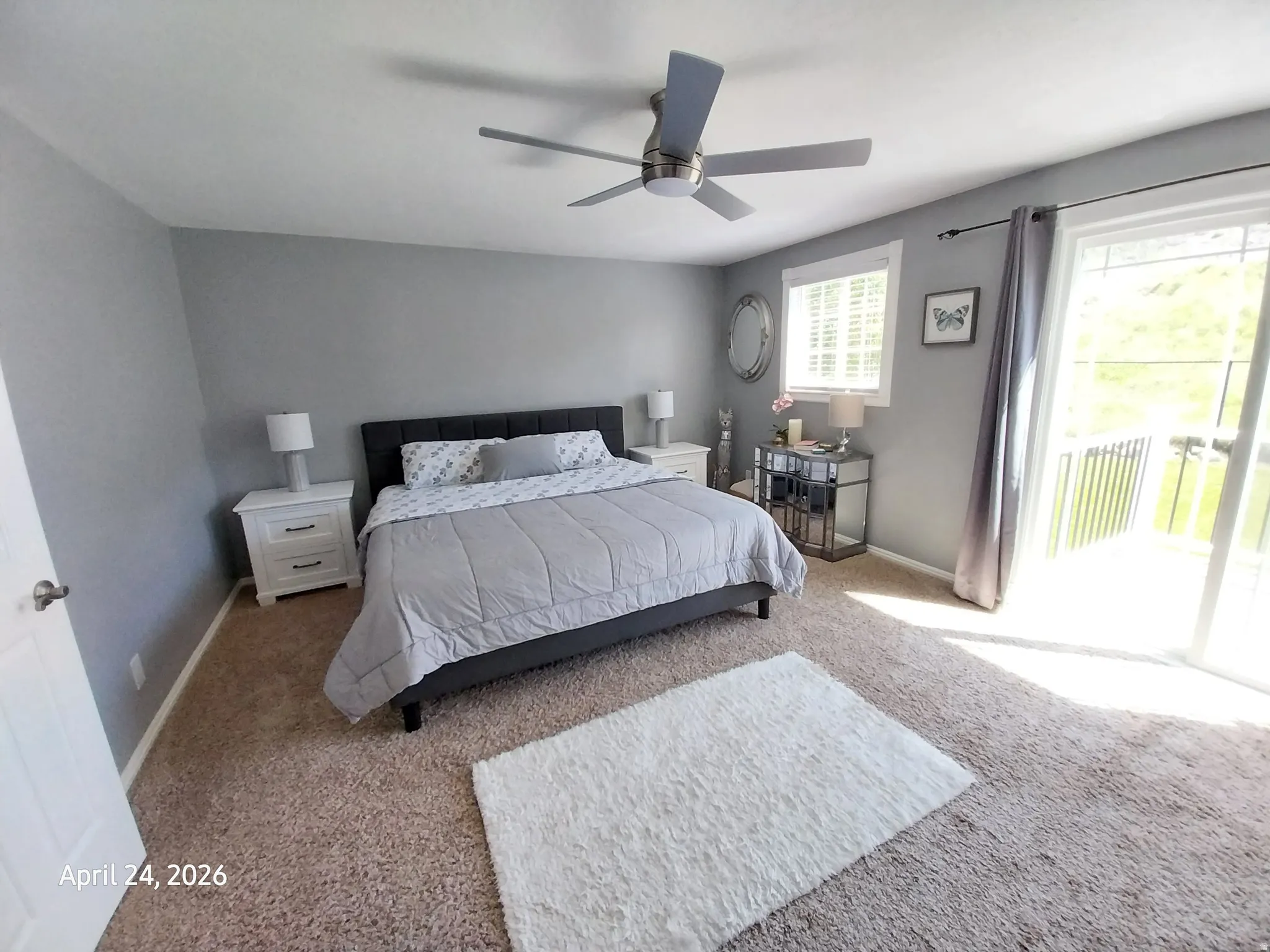 Master bedroom featuring access to exterior, a ceiling fan, and light colored carpet