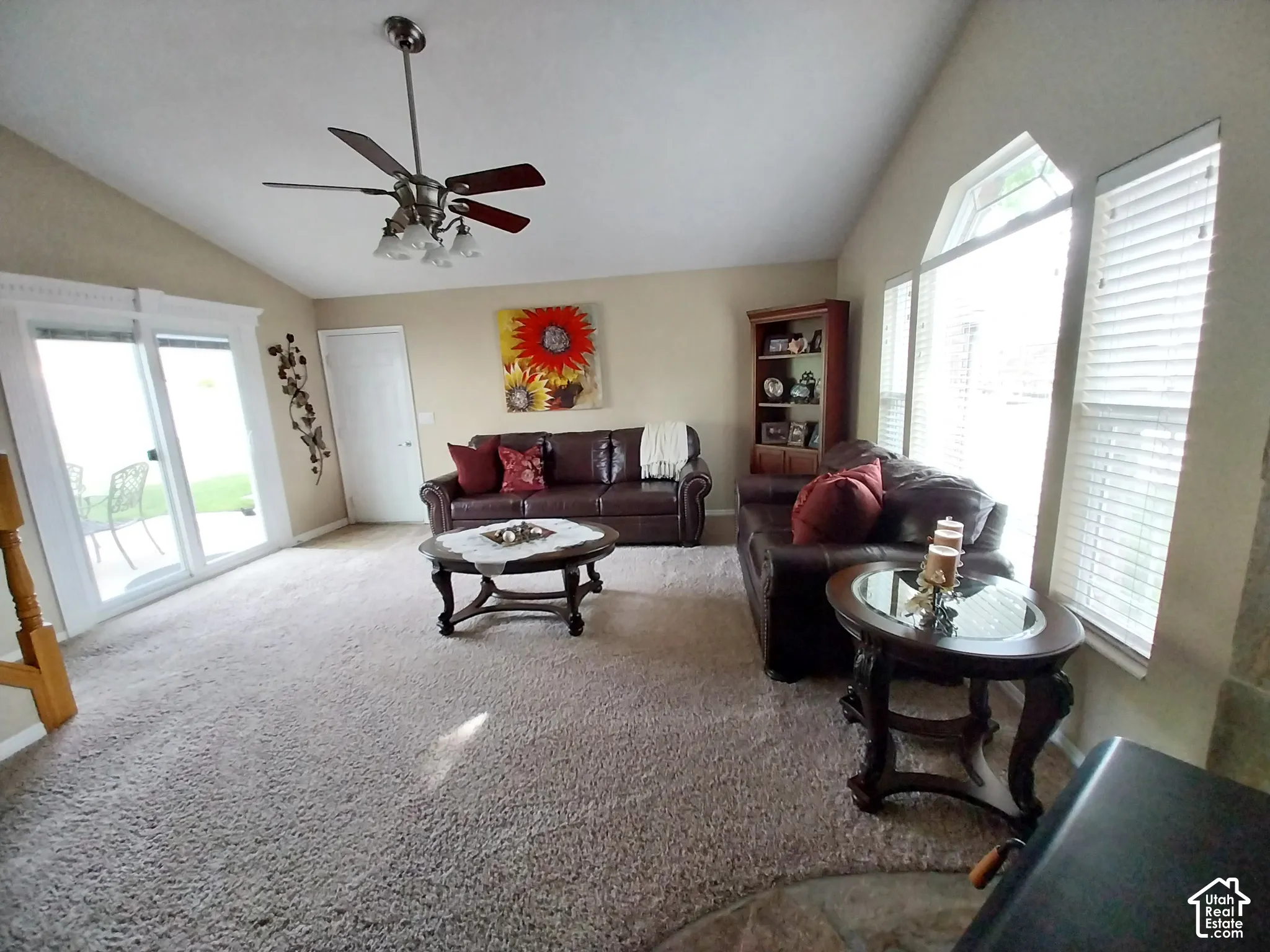 Living room featuring vaulted ceiling, carpet floors, plenty of natural light, and ceiling fan