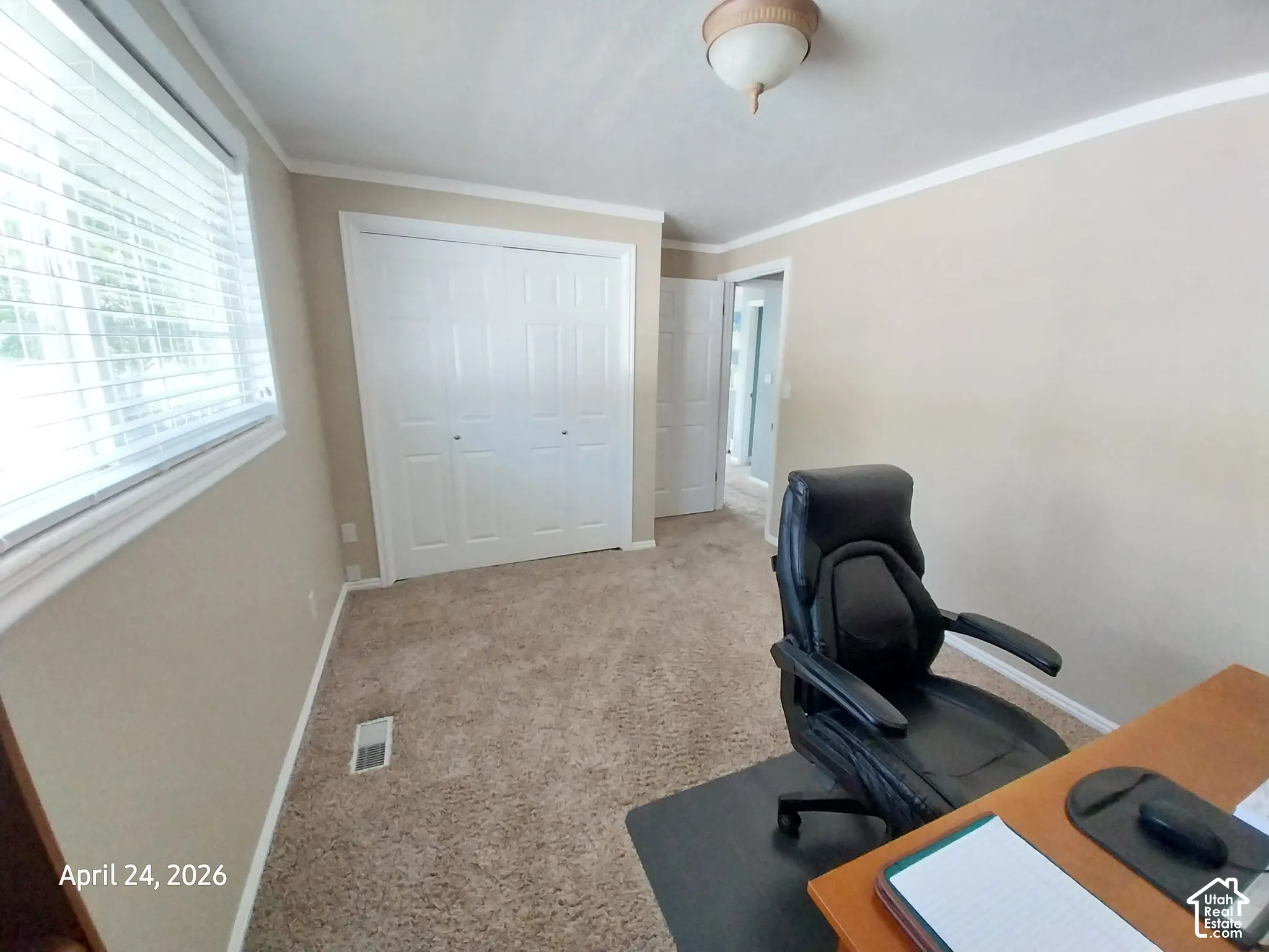 Office space with light colored carpet and crown molding