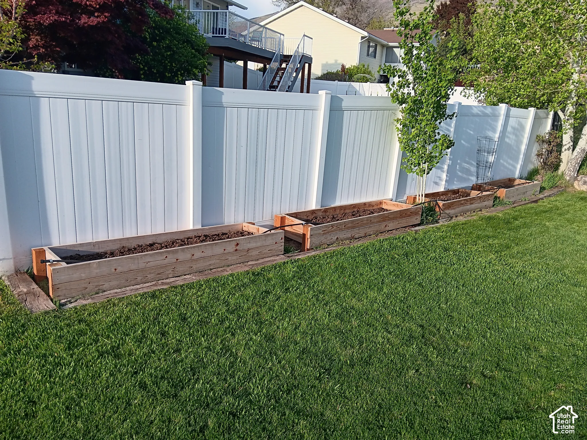 Fenced yard featuring Red wood raised beds/ vegetable garden