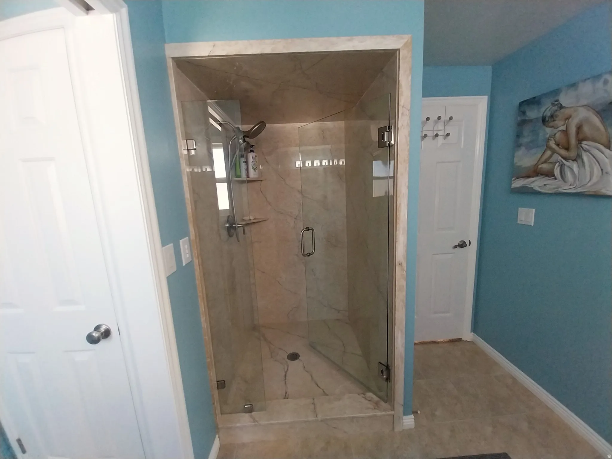 Bathroom featuring a marble finish shower and baseboards