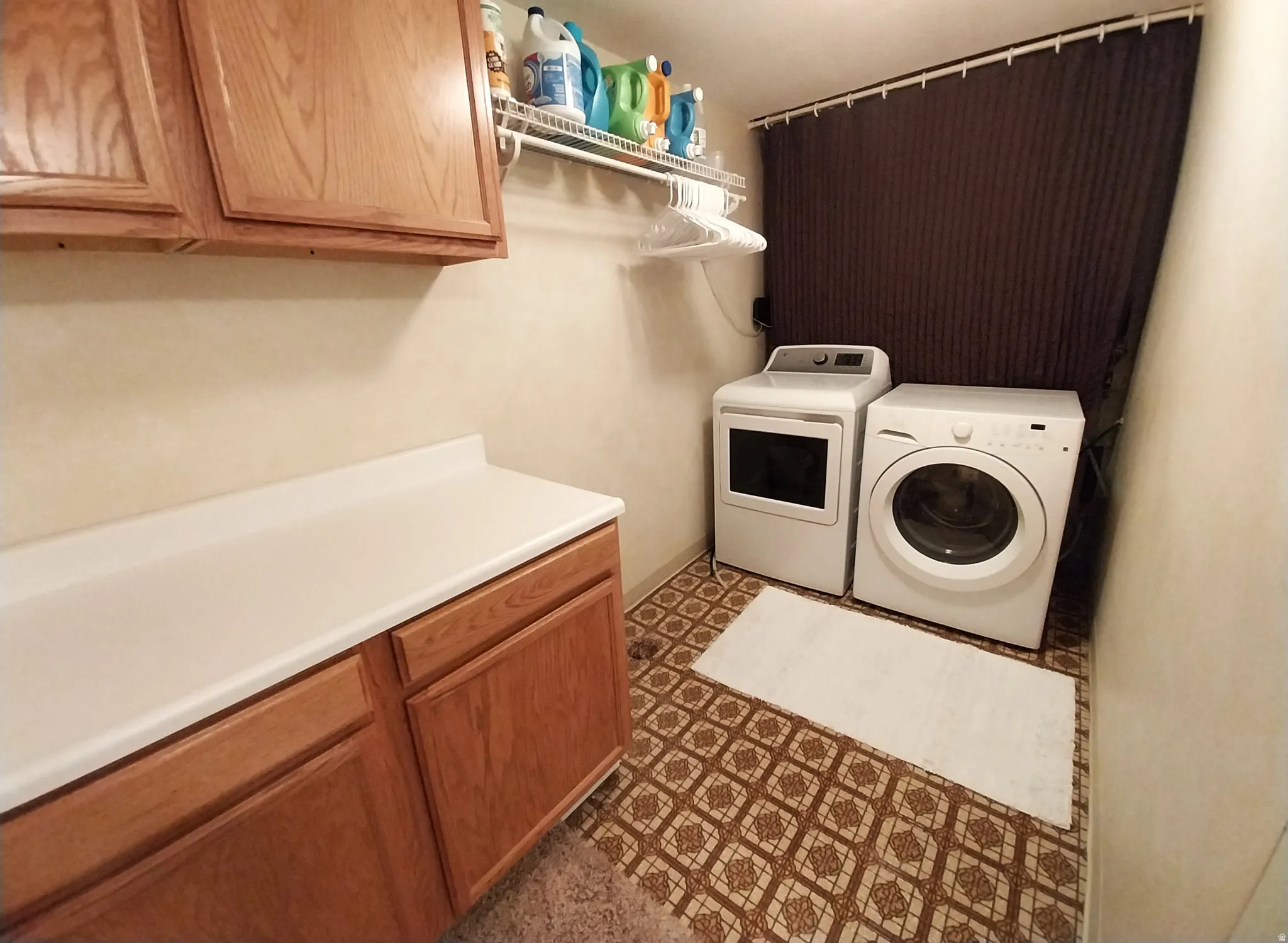 Laundry room featuring cabinet space, washing machine and dryer, and dark floors
