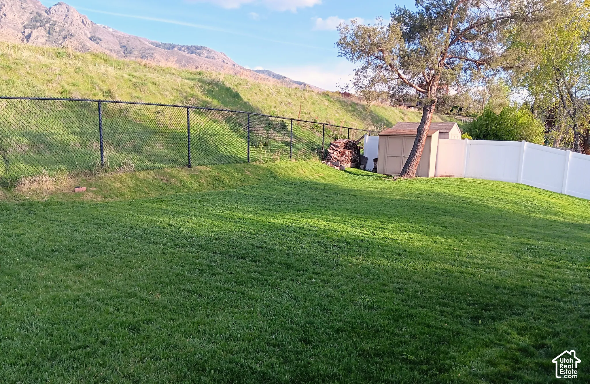 Fenced backyard with a shed and a mountain view