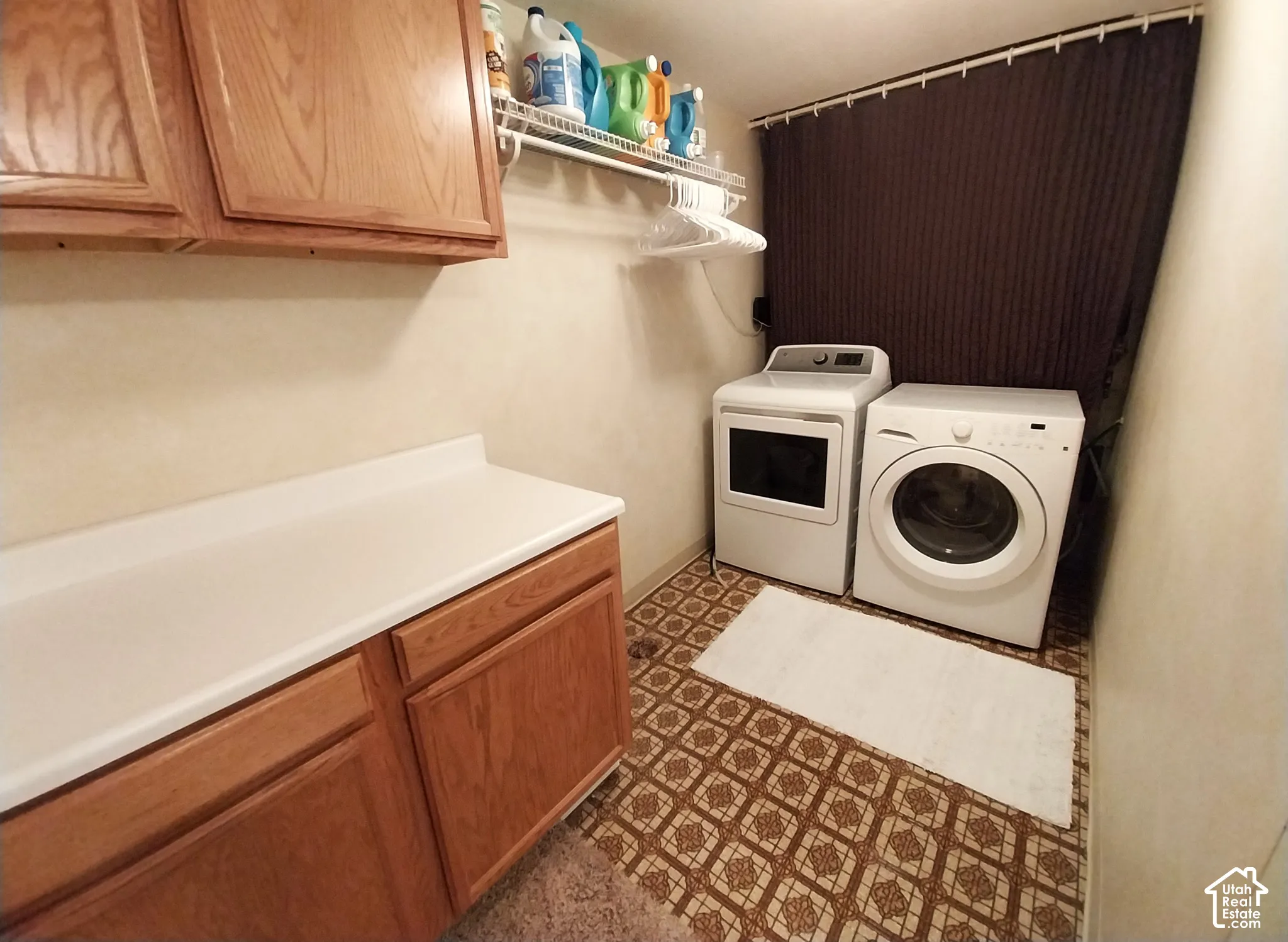 Laundry room featuring cabinet space, washing machine and dryer, and dark floors